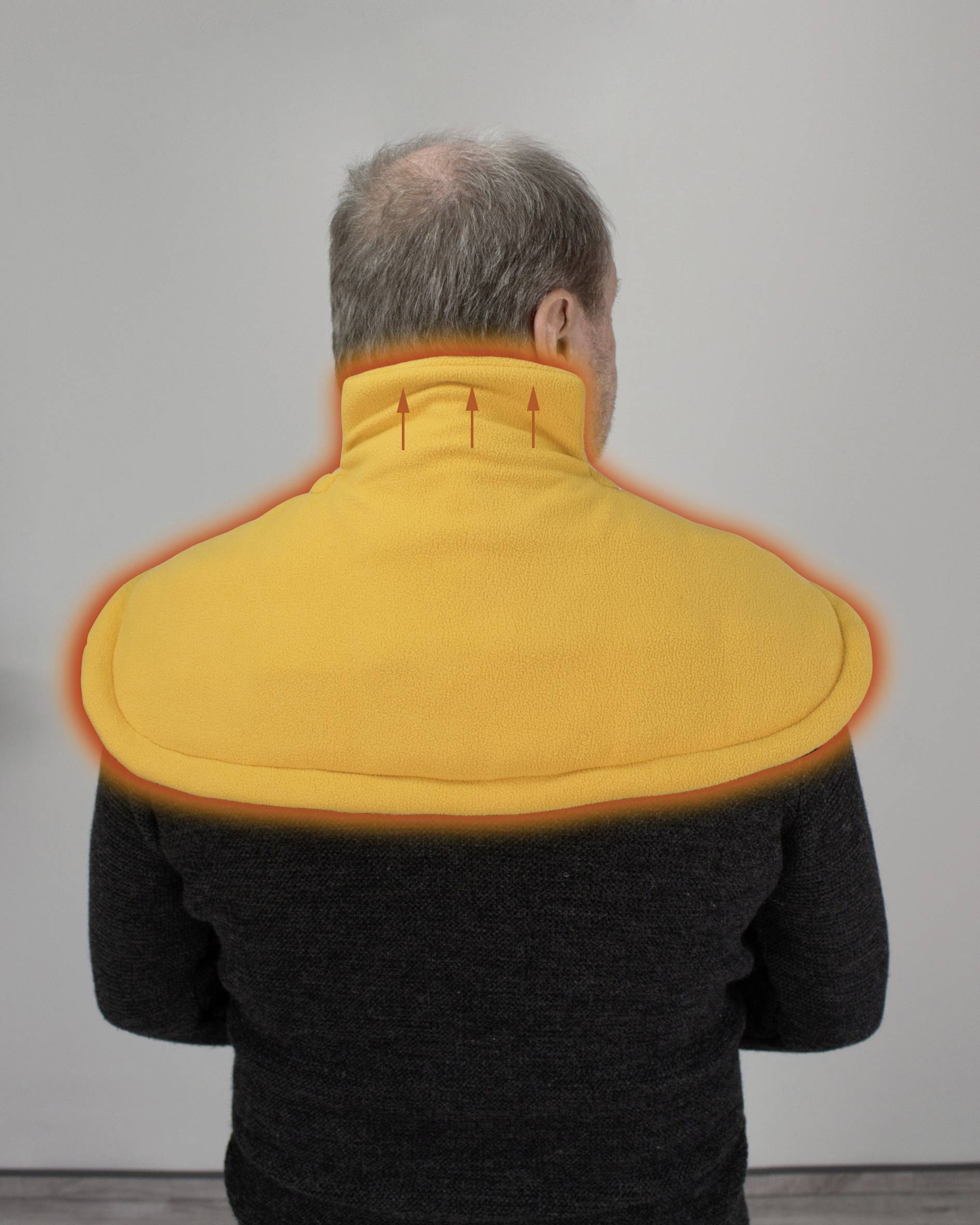 Osoba s šedivými vlasy nosí oranžový nákrčník. Červené šipky znázorňují stoupající teplo nad páteří.