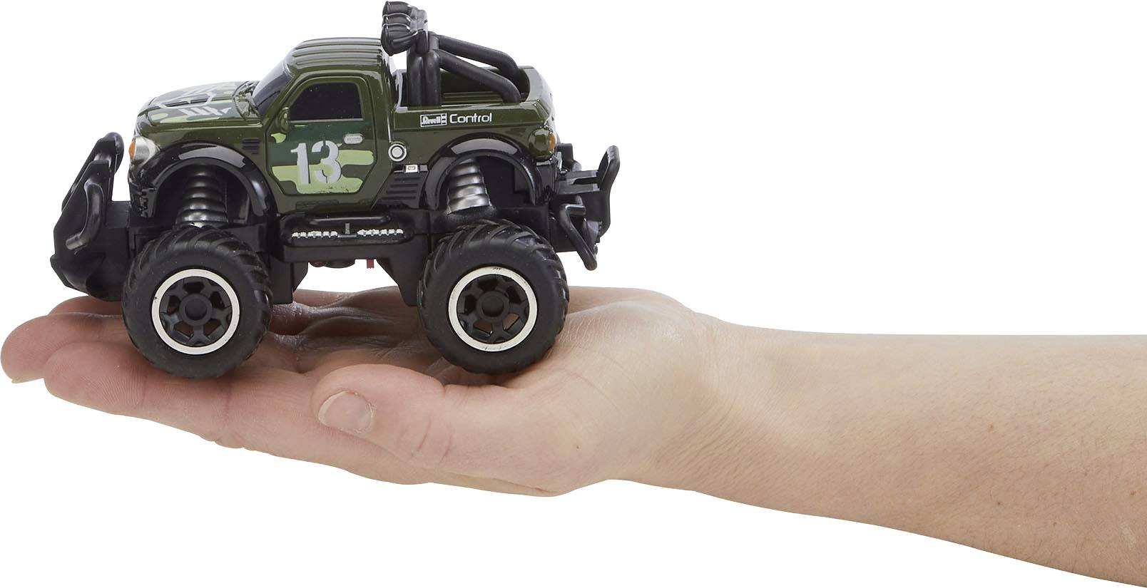 Ruka drží malý zelený hračkářský monster truck.