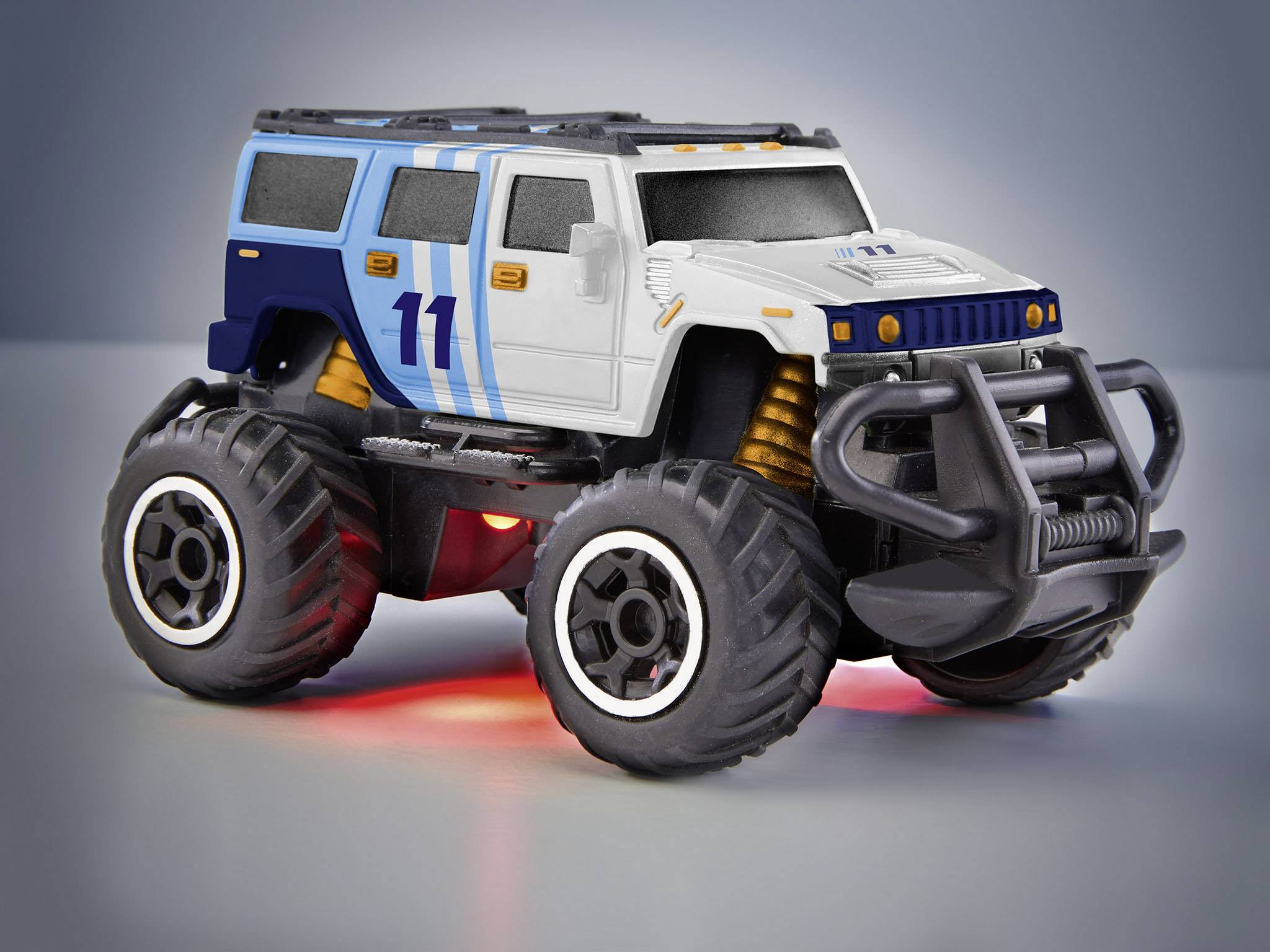 Hračkářské auto ve stylu monster trucku s modrou číslovkou '11', velkými koly a nárazníkem na šedém pozadí.