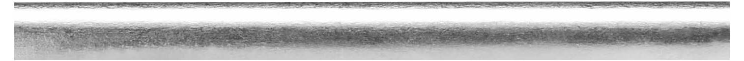 Horizontální, opakující se monochromatický pruhovaný přechod od tmavě šedé po bílou, táhnoucí se shora dolů, s texturou.