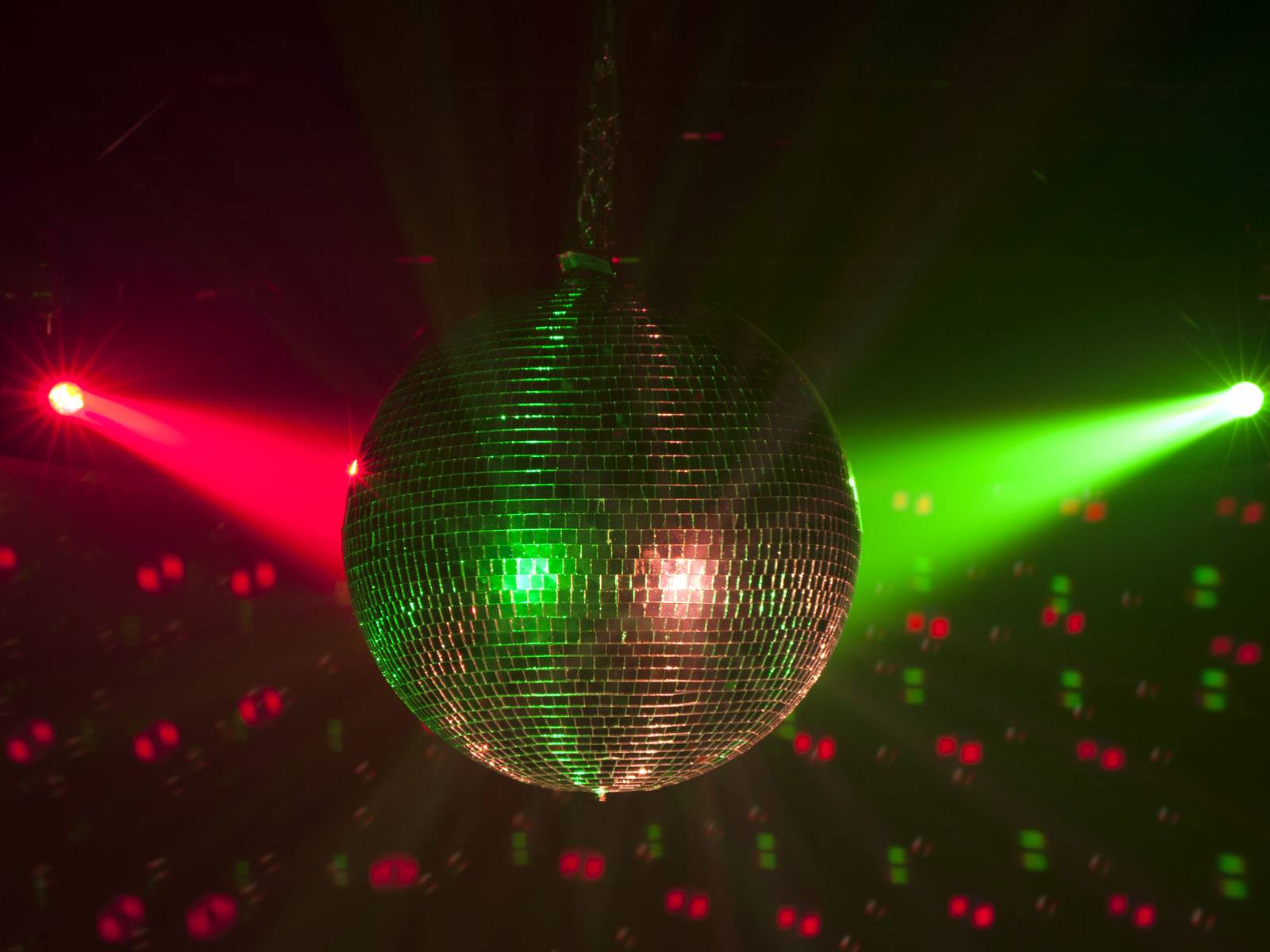 Disco koule odráží pestré světlo v tmavém prostoru a vytváří živoucí atmosféru.