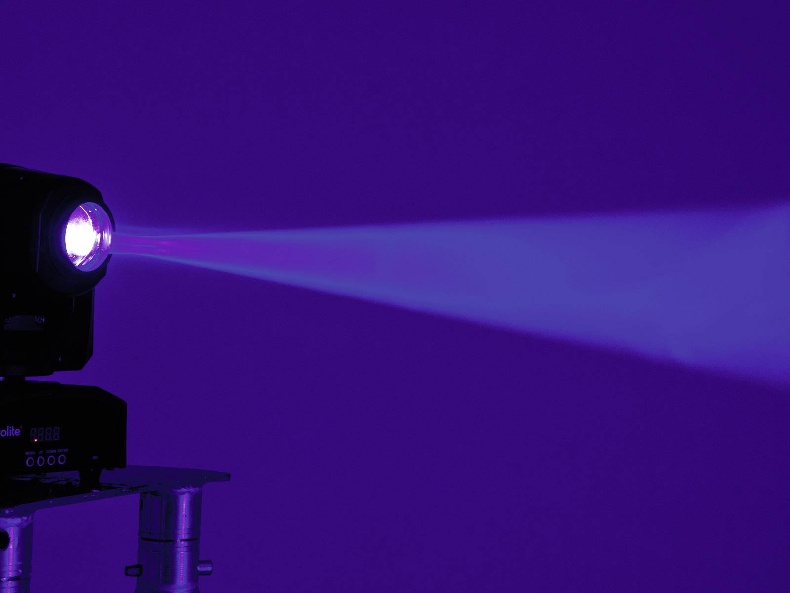 Reflektor promítá modrý světelný paprsek do tmavé místnosti.