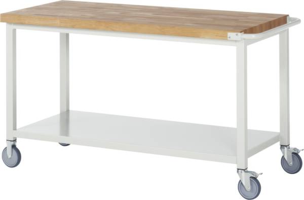 Stabilní pracovní stůl s dřevěnou deskou, bílou kovovou konstrukcí a čtyřmi kolečky. Ideální do dílen nebo hobby místností.