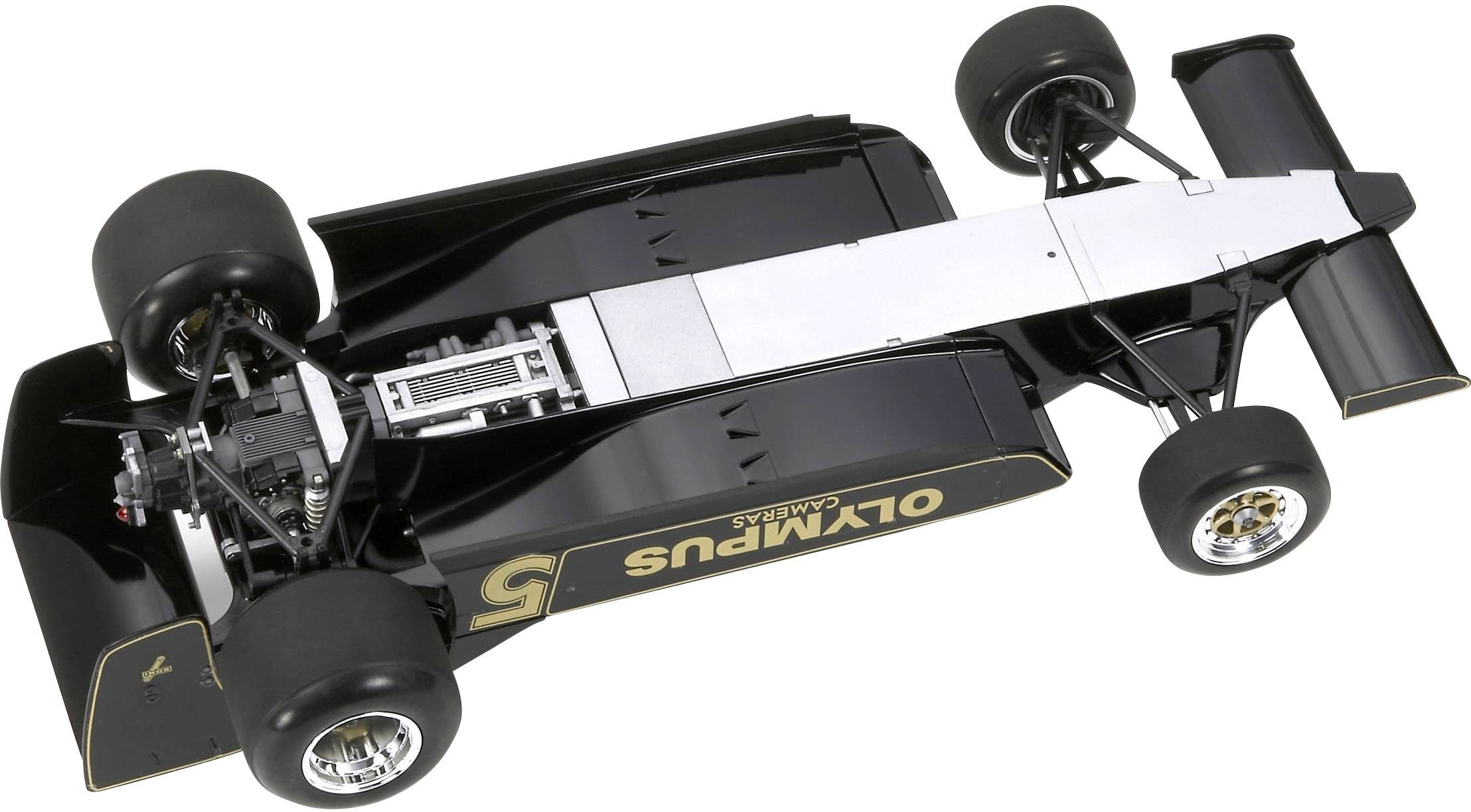 Černý formulový vůz se zlatými pruhy a nápisem 'OLYMPUS' na boku, fotografovaný shora.
