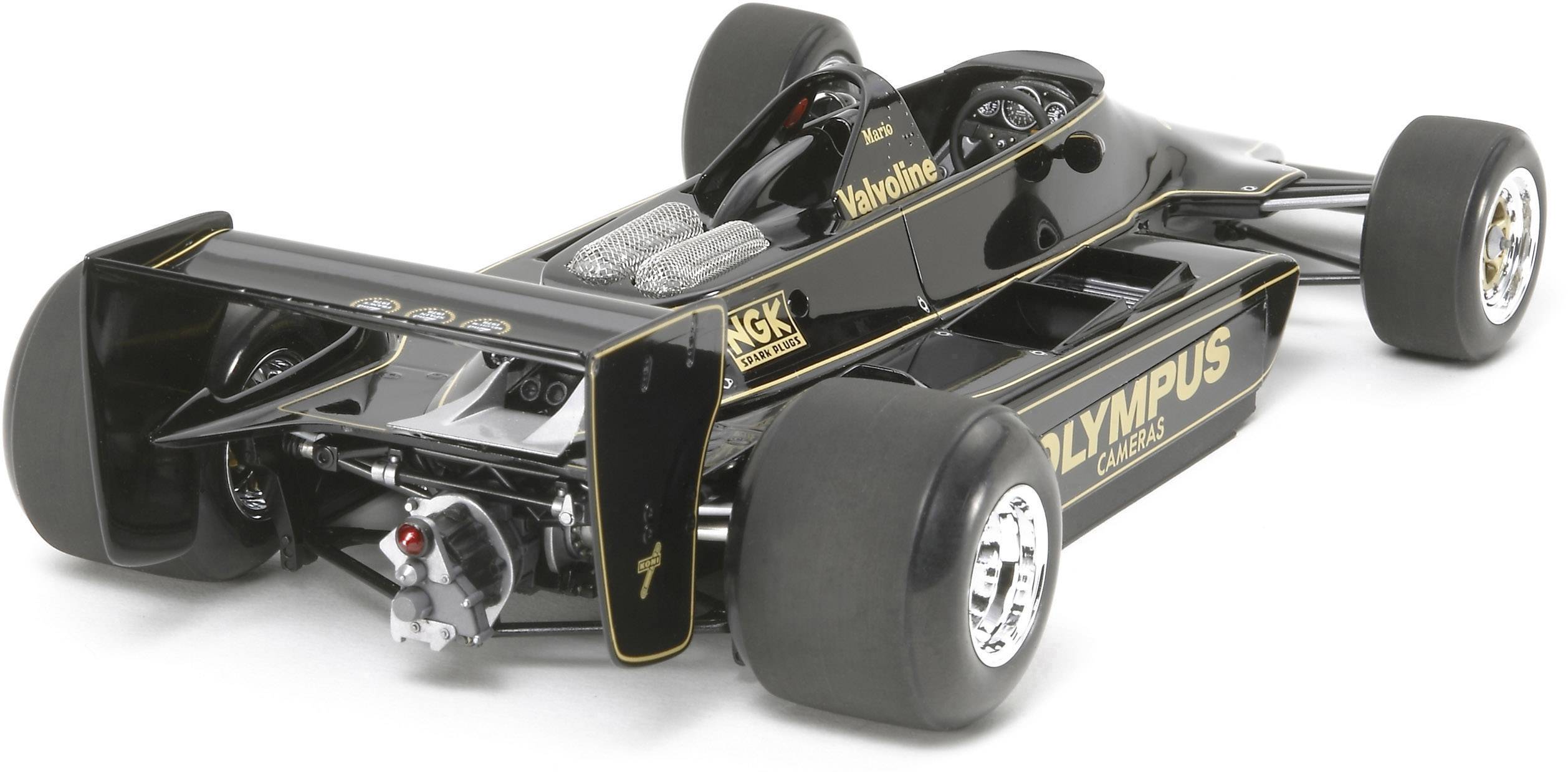 Černé modelové auto se zlatými linkami, které se podobá formuli 1. Na boku je napsáno 'Olympus'.