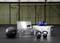 Fitness studio s CrossFit vybavením: medicinbal, kettlebell, hliníkové bedny a sportovní rukavice na podlaze před kruhy a hrazdou.