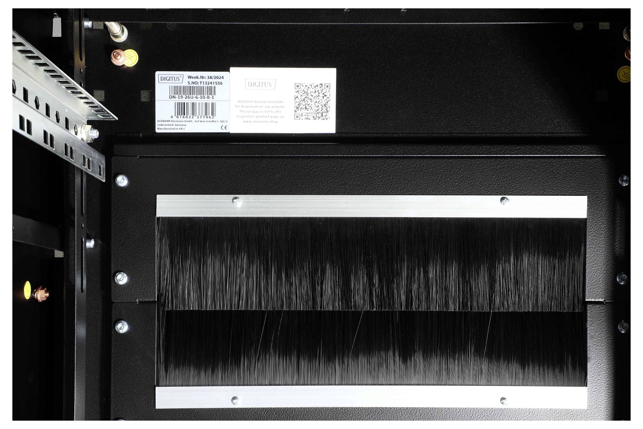 Serverový chassis s kartáčem pro správu kabeláže a štítkem s QR kódem. Horní oblast ukazuje větrací otvory a montážní úhelníky.