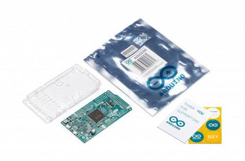 Deska Arduino Nano s průhledným pouzdrem vedle obalu a dvou malých samolepek. Hlavní procesor je umístěn uprostřed desky.