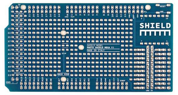Modrá prototypová deska s mnoha kovovými kontaktními body a nápisem 'Shield'. Používá se pro kompatibilitu s Arduino.