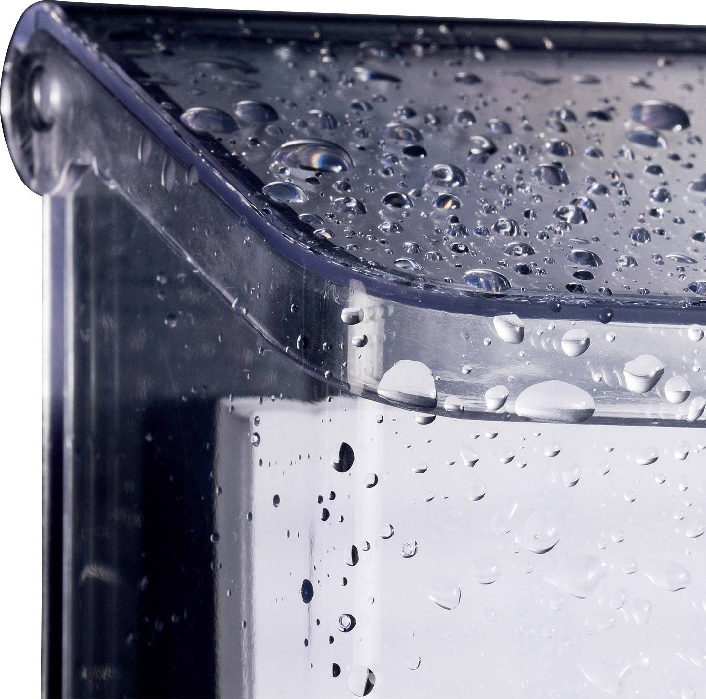 Průhledná nádoba s kapkami vody na povrchu, které naznačují nedávné postříkání nebo vlhkost.