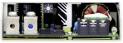 Vnitřní pohled na elektrické zařízení s různými elektronickými komponenty, jako jsou cívky, konektory a kondenzátory.
