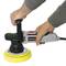 Osoba drží leštičku s žlutým leštícím kotoučem, zatímco s ní zpracovává povrch.