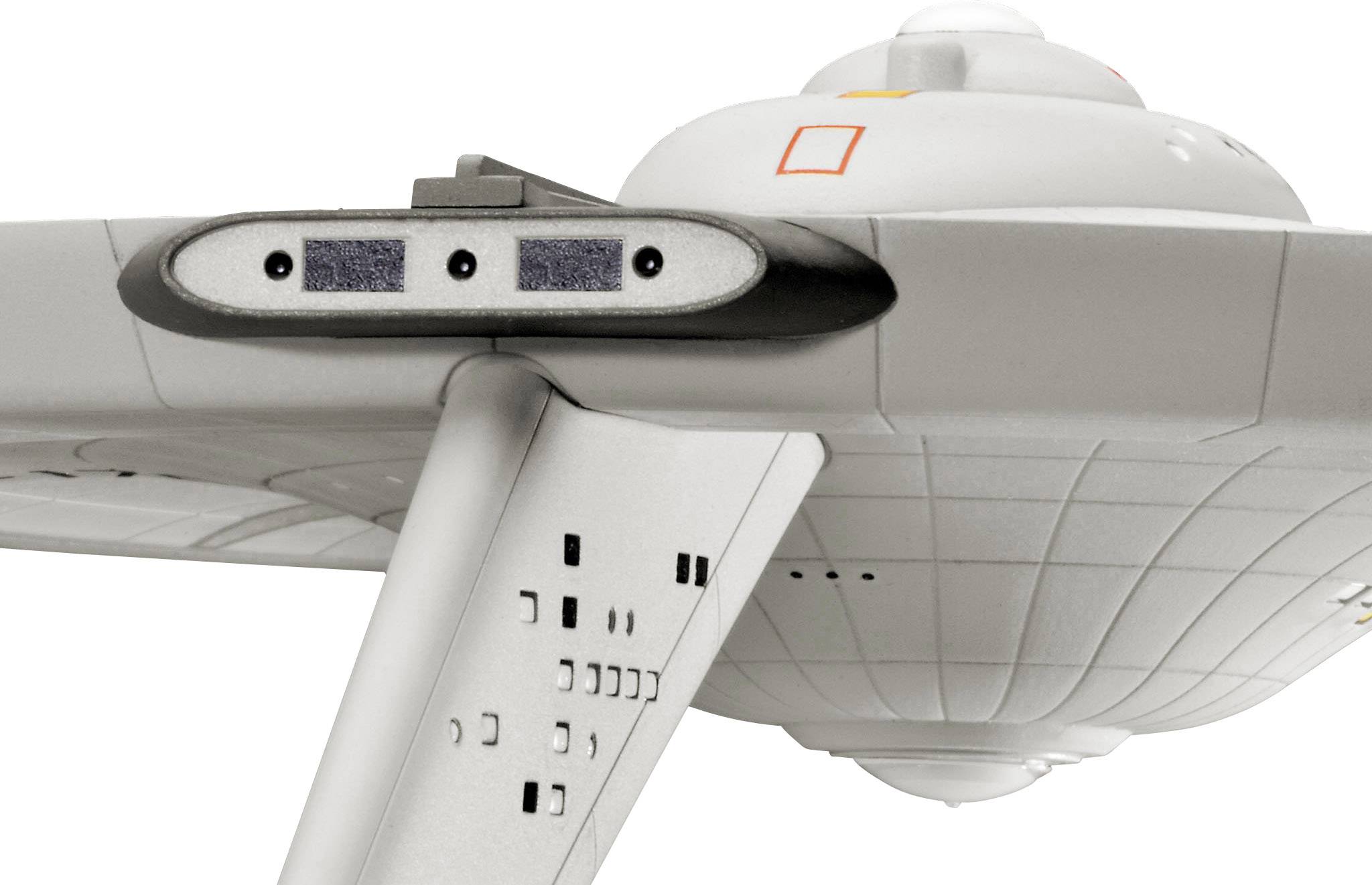 Model futuristické vesmírné lodi s hladkým šedým trupem a viditelnými technickými detaily na křídlech.