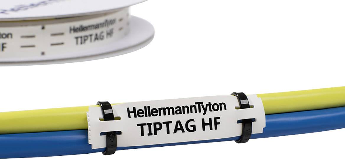 Štítek pro značení kabelů s nápisem 'HellermannTyton TIPTAG HF', připevněný na žlutých a modrých kabelech.