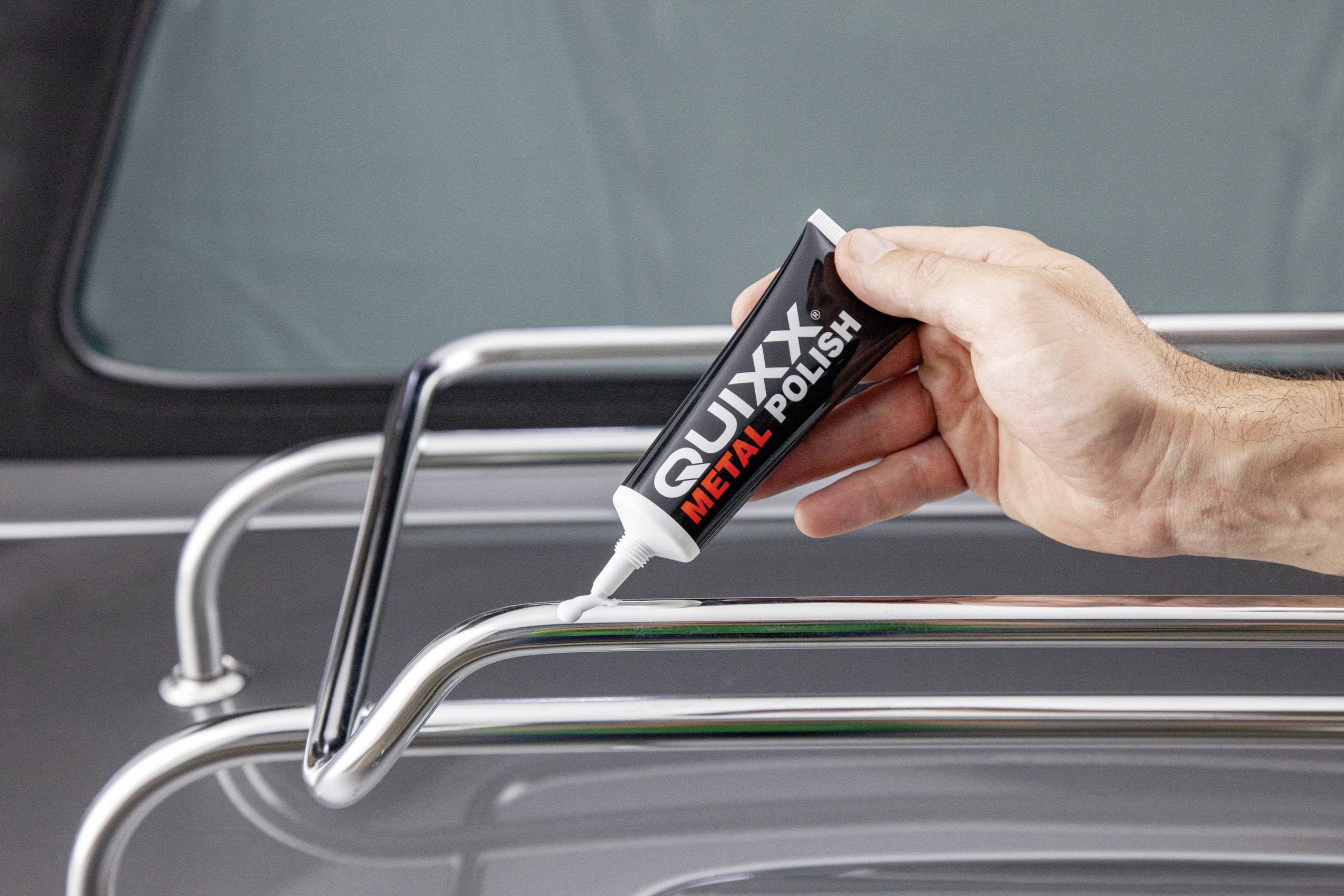 Ruka nanáší 'QUIXX Metal Polish' na chromovaný kov.