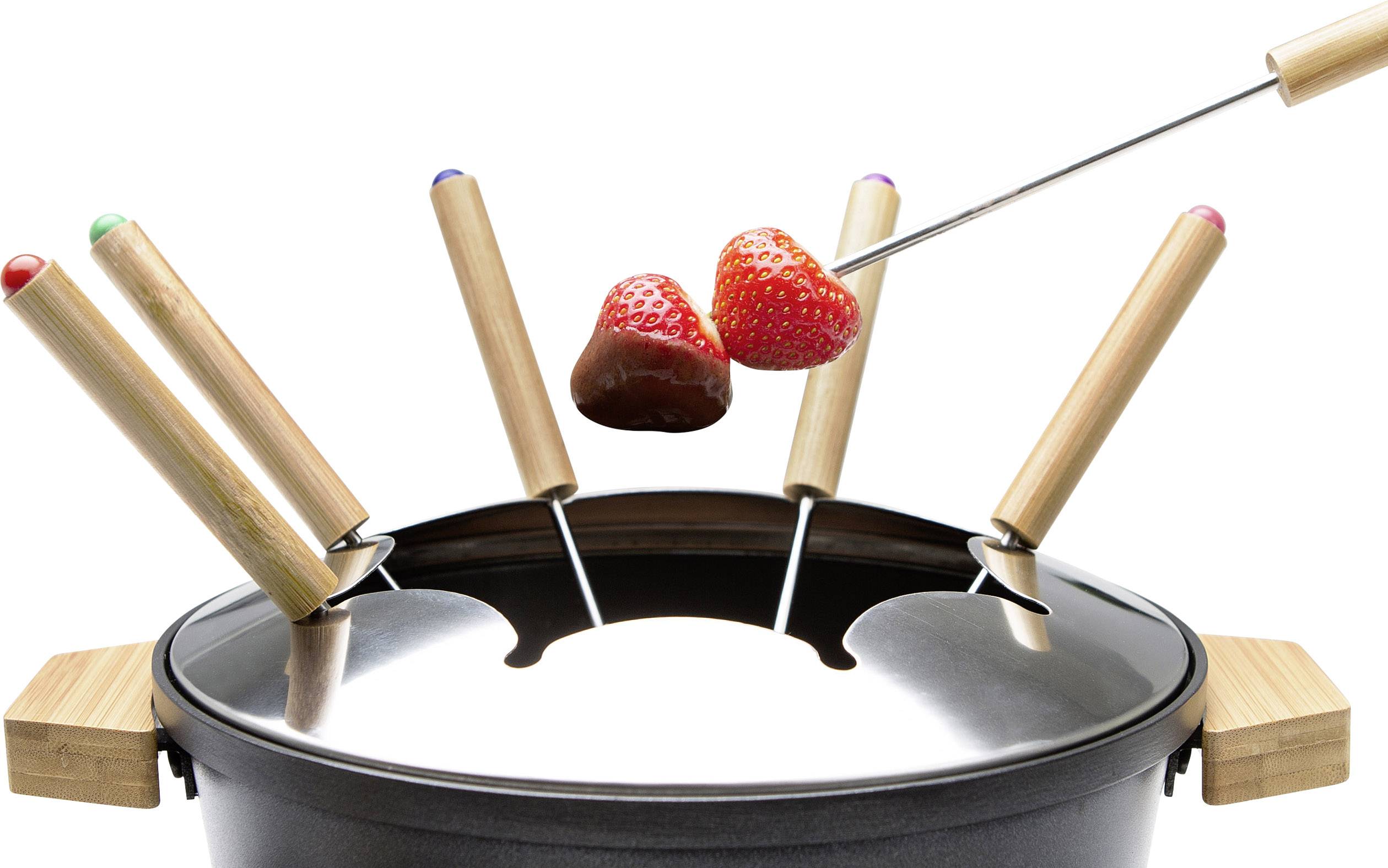 Fondue s dřevěnými špejlemi, na nichž je jahoda a jahoda potažená čokoládou, před bílým pozadím.
