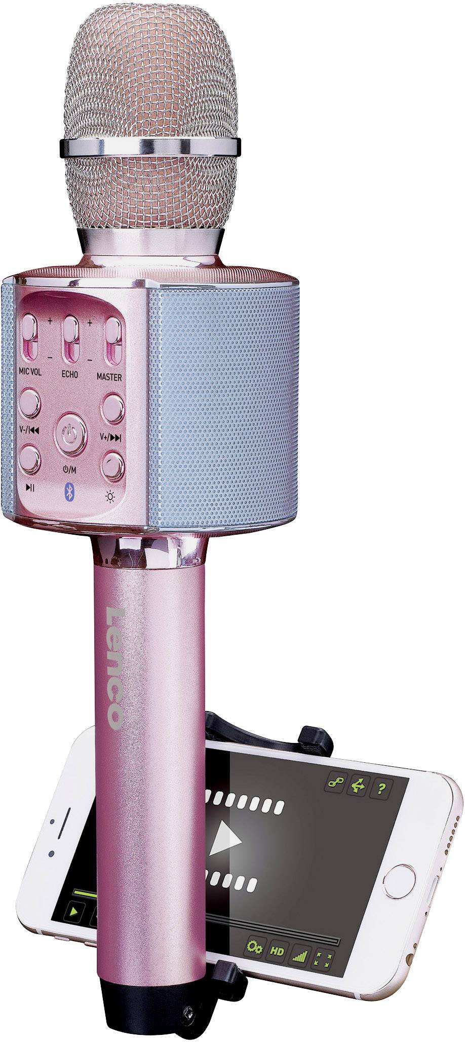 Růžový karaoke mikrofon s vestavěným reproduktorem a ovládacími prvky, včetně připojeného smartphonu sloužícího jako displej pro zobrazení textu písní.