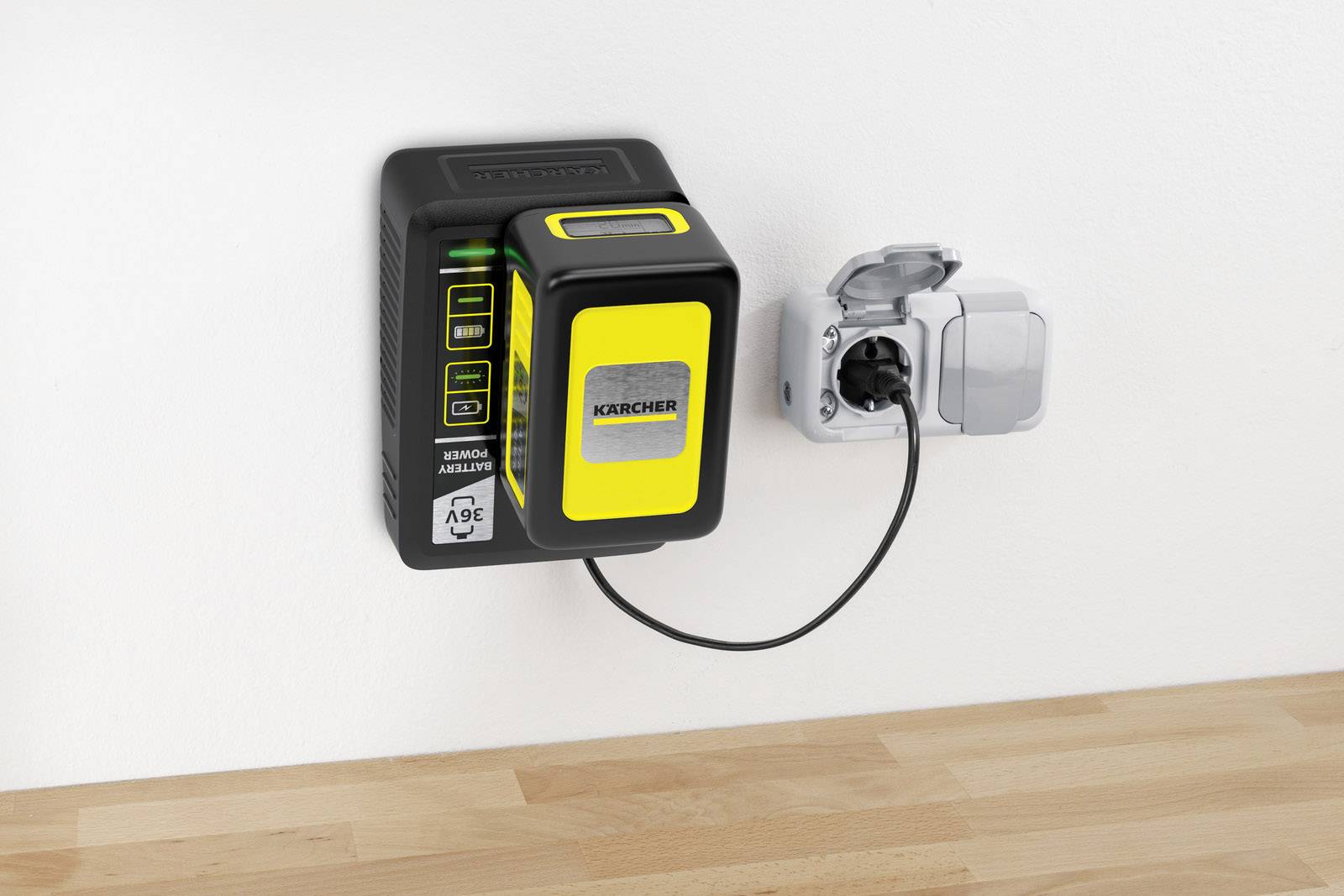 Nabíječka akumulátorové baterie značky Kärcher, připojená do elektrické zásuvky na stěně nad dřevěnou podlahou.