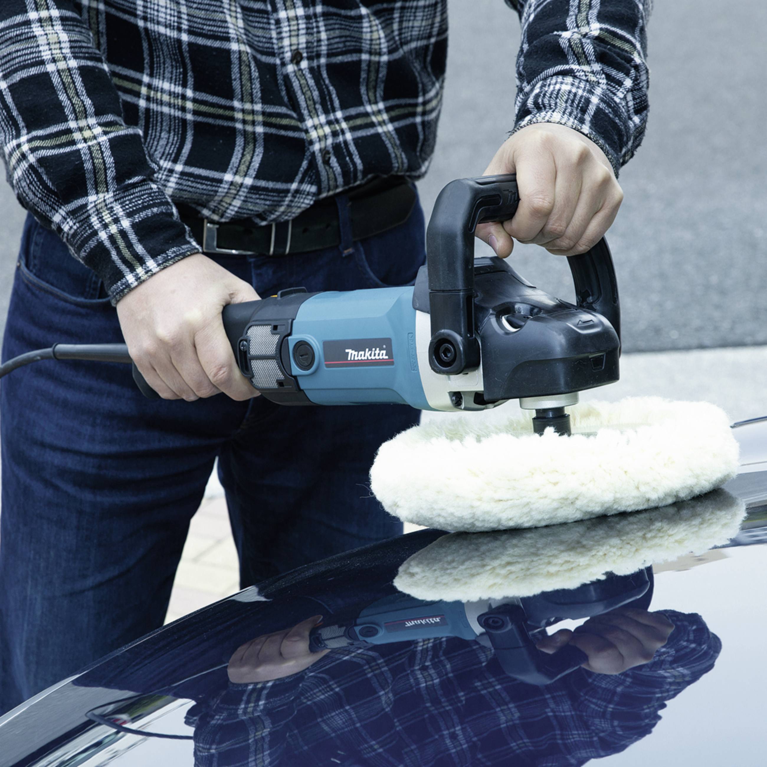Jedna osoba leští pomocí modré leštičky motorovou kapotu automobilu. Leštička má bílý nástavec.