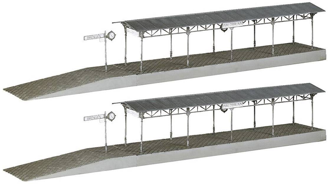 Dva souběžně umístěné modely železničních nástupišť s přístřeškem a bočním štítkem 'Nástupní plocha'. Ideální pro modelové železniční rozložení.