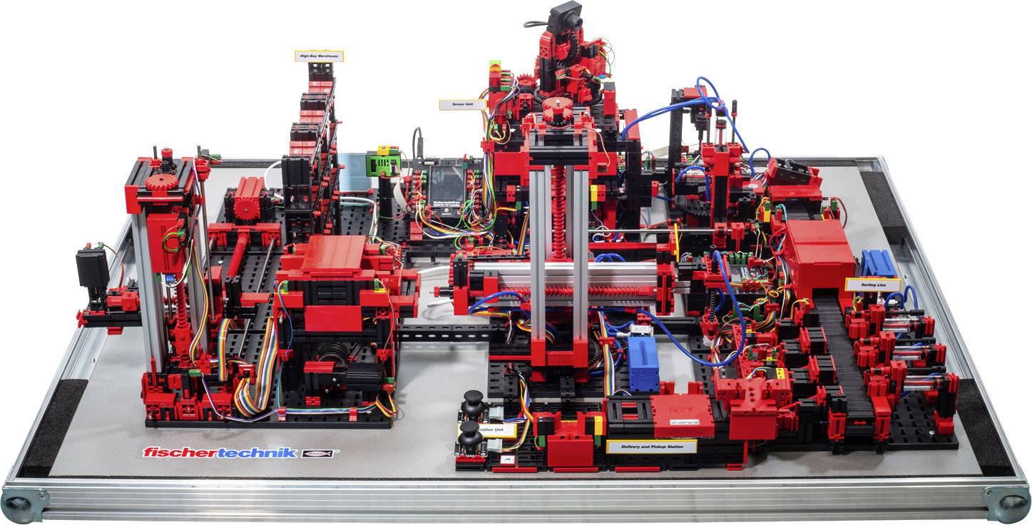 Komplexní model z červených a černých součástí zobrazující automatizovanou výrobní linku s různými pracovními stanicemi.