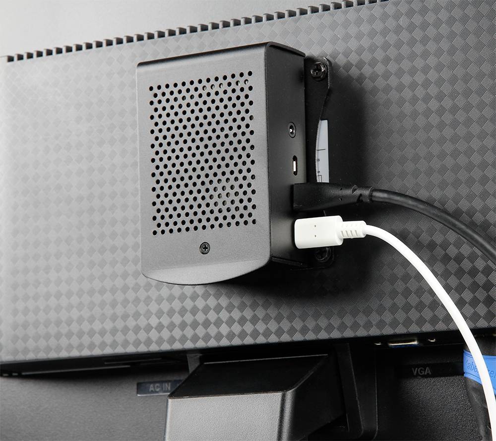 Malý černý reproduktor je namontován na zadní straně monitoru. Bílý kabel je připojen.