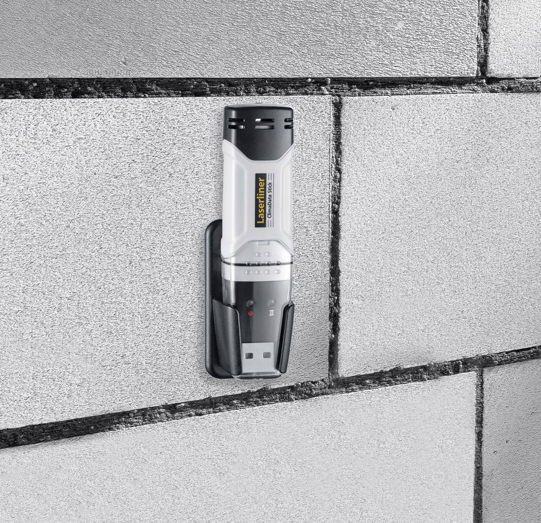 Digitální laserový dálkoměr se používá na cihlové zdi k provedení přesných měření.