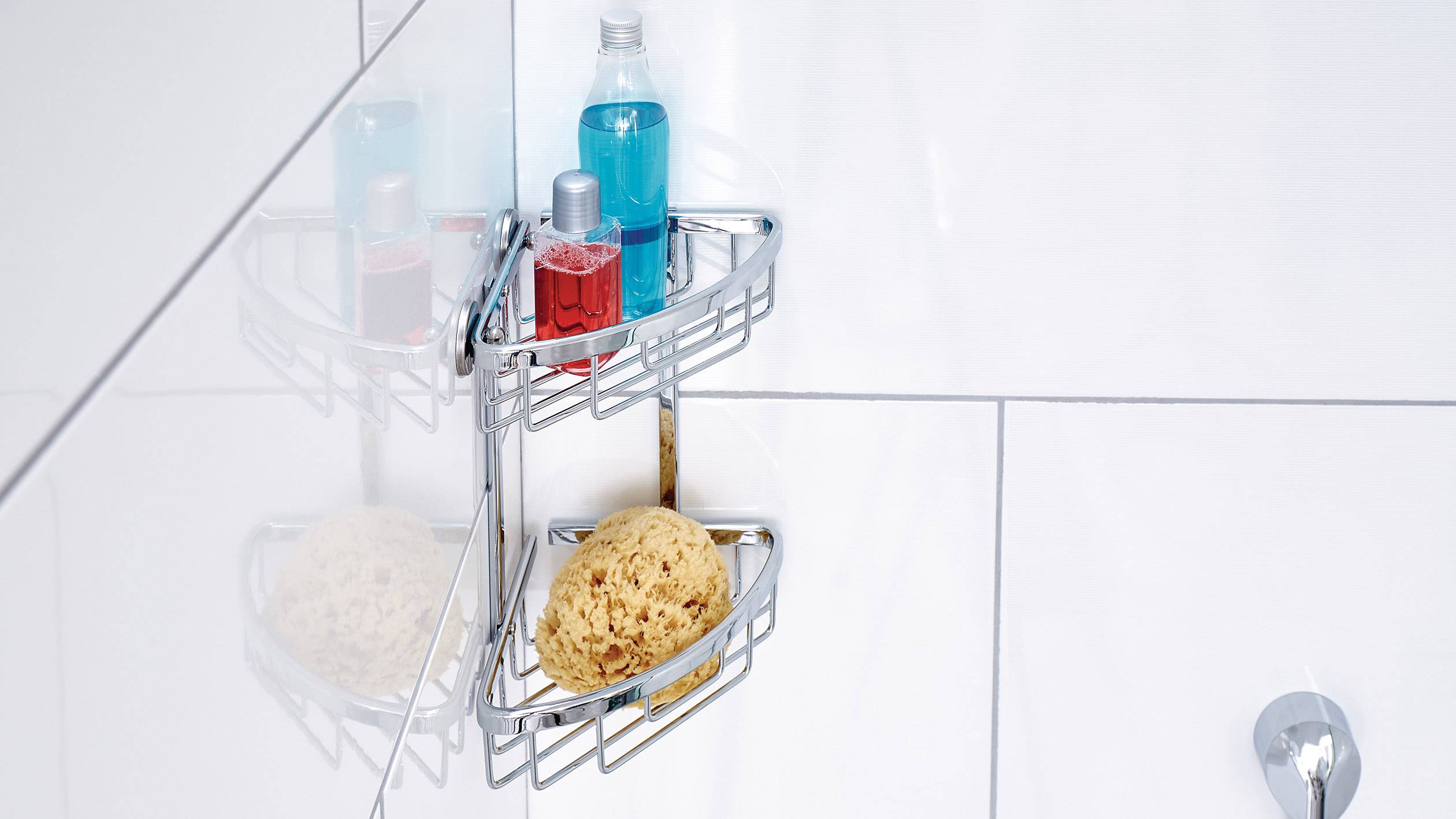 Sprchový košík na obložené stěně, s červeným a modrým sprchových gelem a houbičkou.