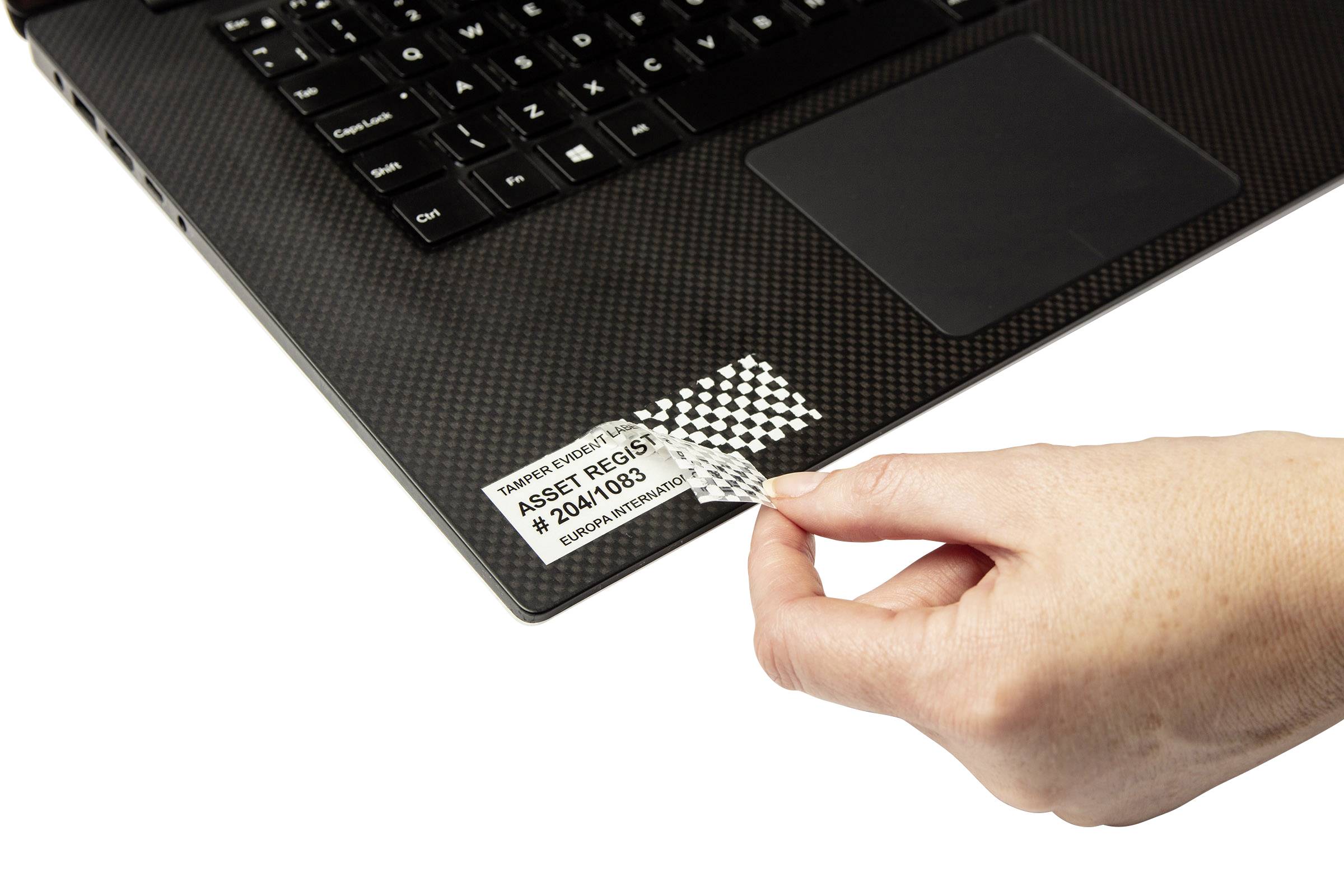 Ruka odstraňuje bezpečnostní pečeť z laptopu.