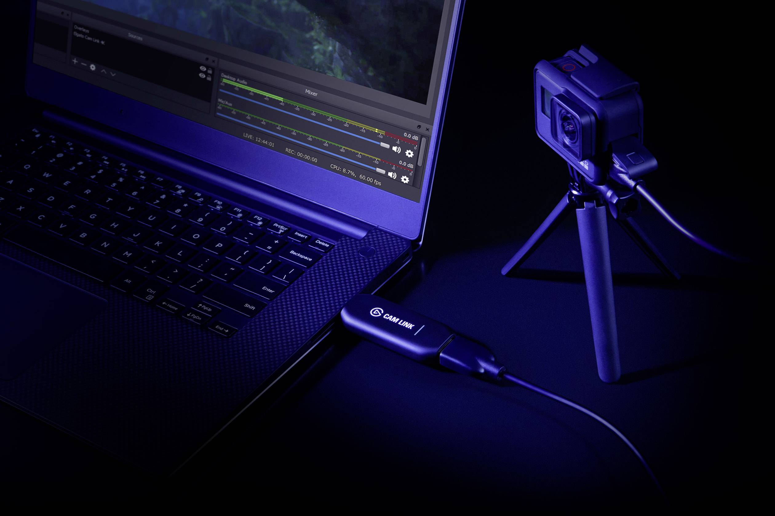 Laptop je pomocí kabelu připojen ke kameře umístěné na stativu, vše je zobrazeno v tmavém, technicky laděném prostředí.