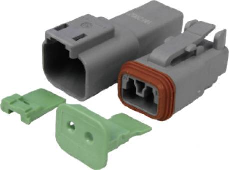 Šedý elektrický konektor se dvěma zelenými kryty, jeden obdélníkový, druhý rohový, na bílém pozadí.