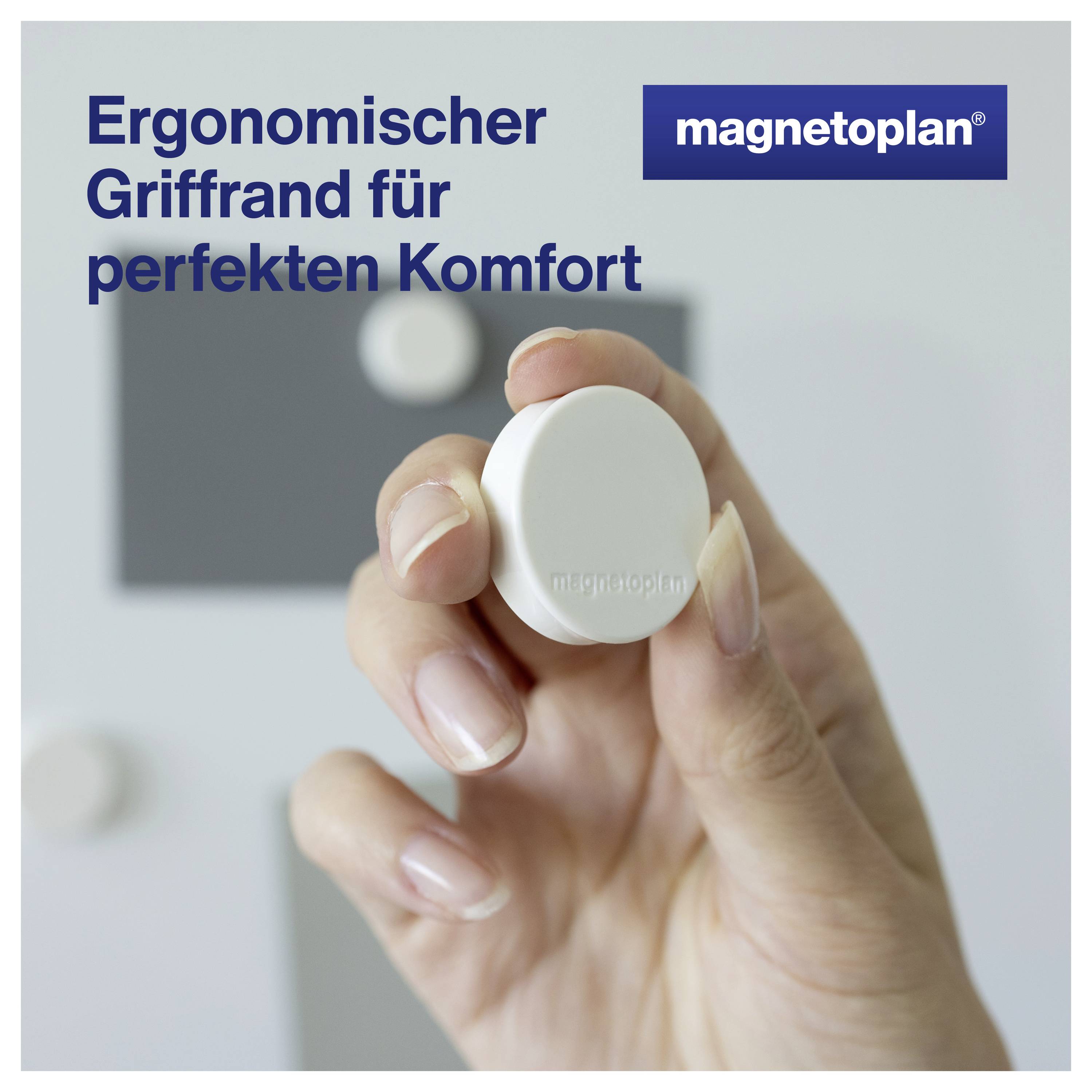 Jedna ruka drží ergonomicky tvarovaný bílý magnet před šedým pozadím. Text: 'Ergonomický okraj rukojeti pro dokonalý komfort'.