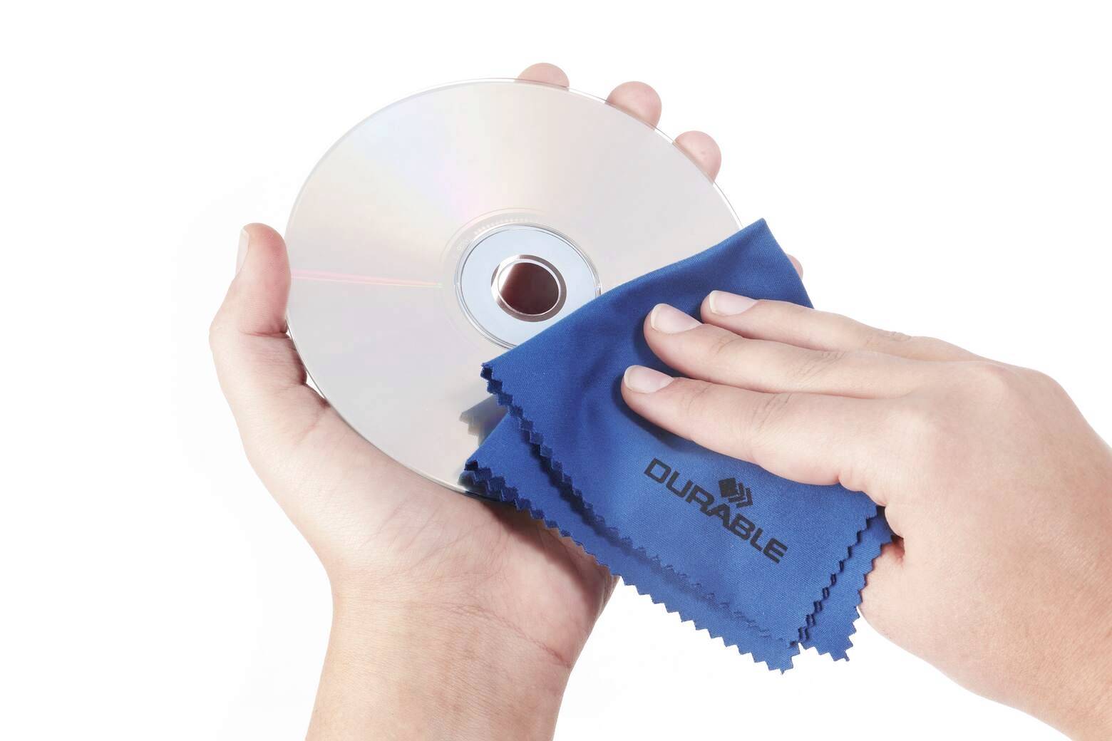 Dvě ruce čistící CD modrým hadříkem označeným jako Durable.