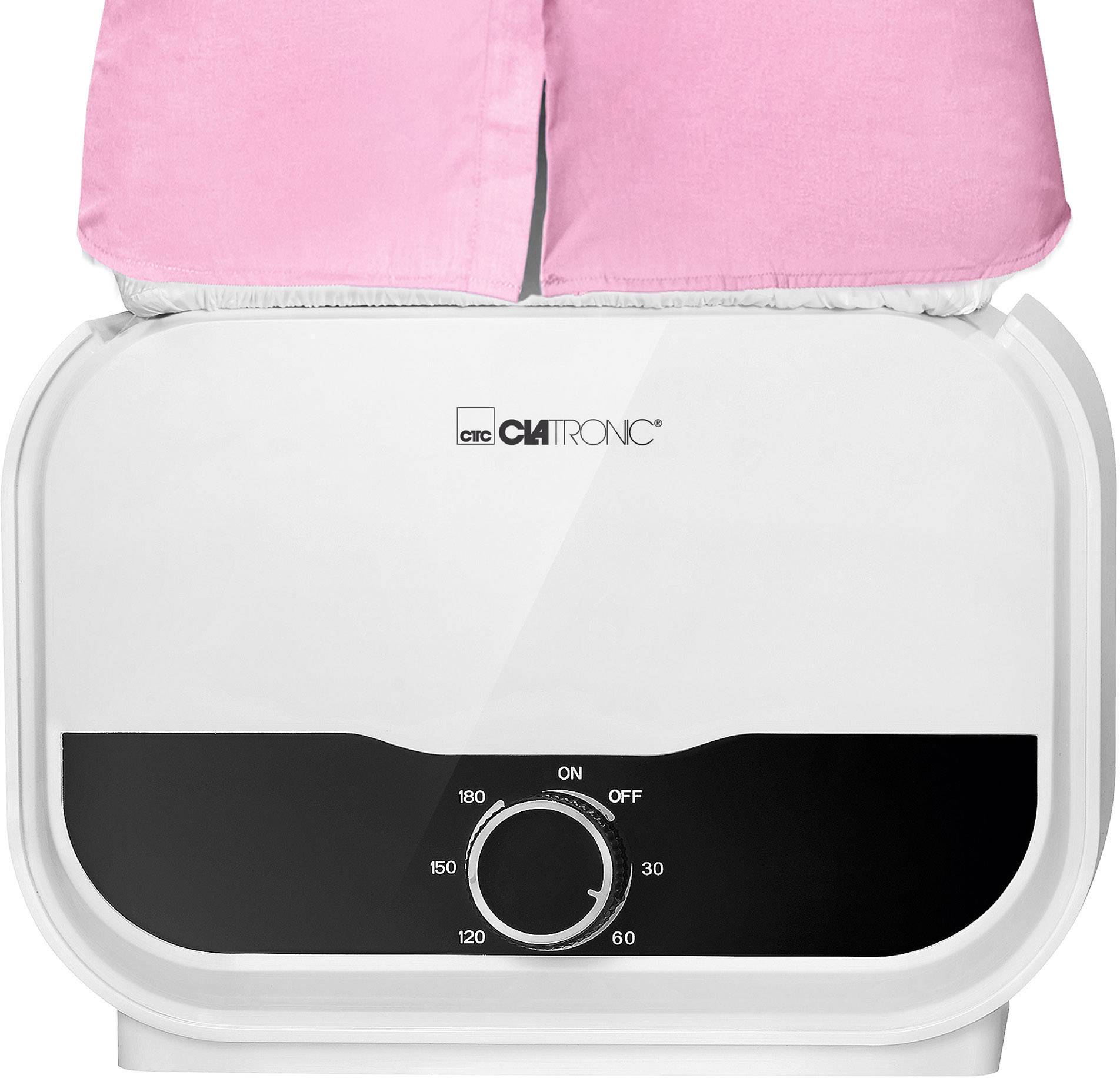 Elektrická parní žehlička suší a žehlí růžový kus oblečení. Otočný knoflík ukazuje nastavení teploty.