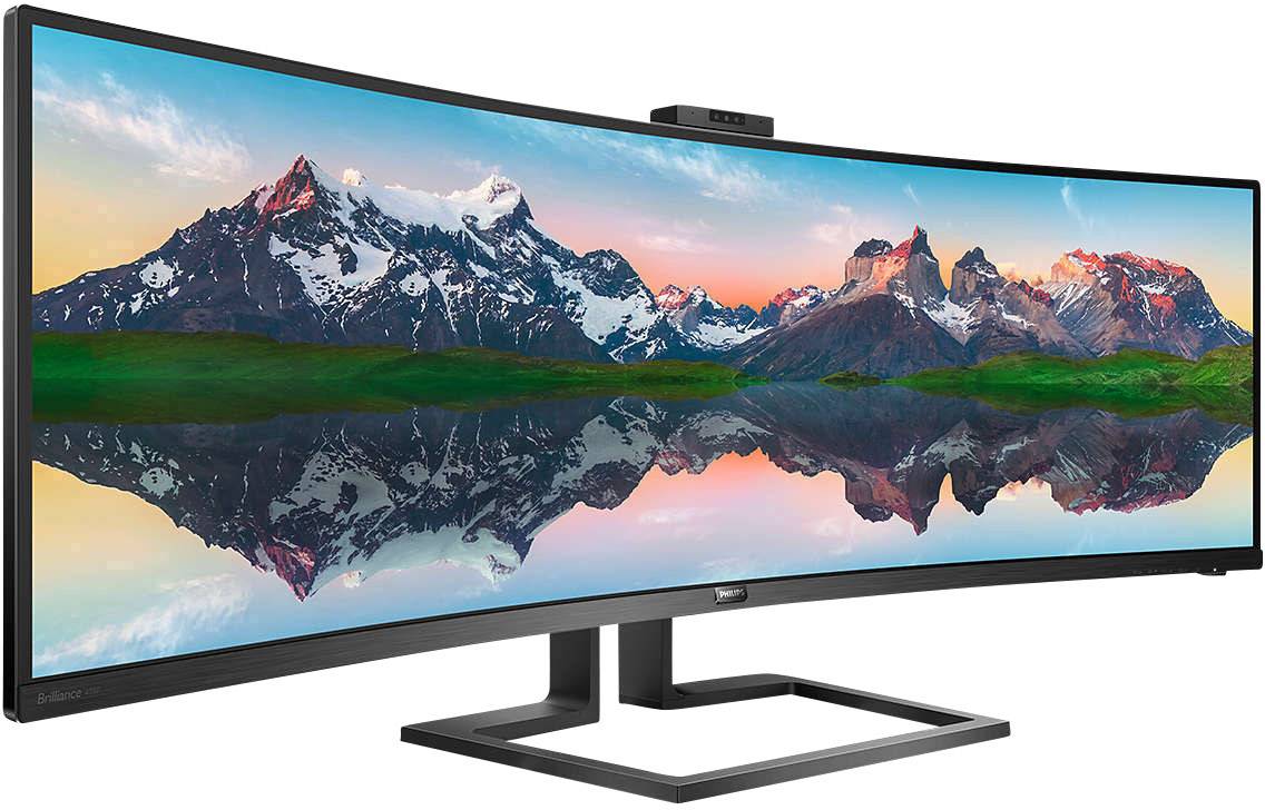 Široký zakřivený monitor zobrazuje zářivou horskou krajinu s vodní hladinou odrážející oblohu pod modrým nebem, slouží k prezentaci přírodních snímků.