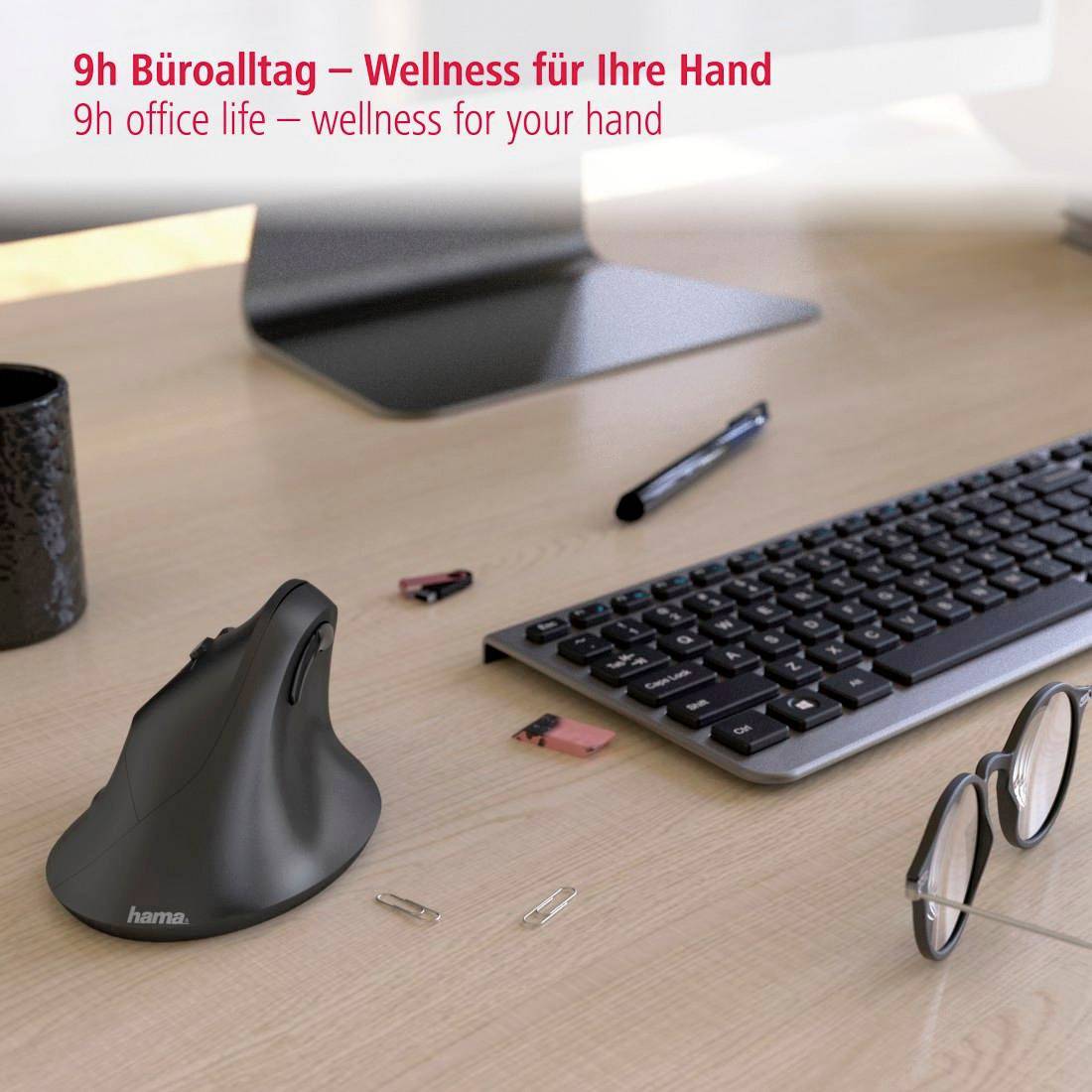 Ergonomická myš na pracovním stole před monitorem, vedle klávesnice a brýle; text: '9h kancelářské rutiny – wellness pro vaši ruku'.