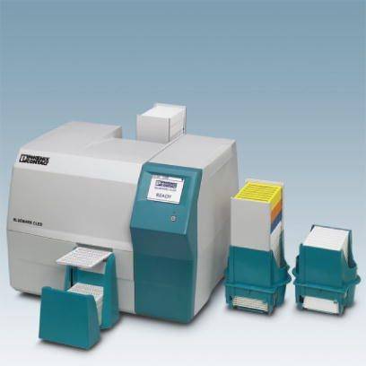 Lékařské laboratorní zařízení s digitálním displejem, na kterém je nápis 'PŘIPRAVENO'. Vedle něj jsou uspořádané zkumavky.