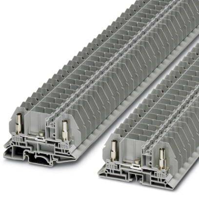 Šedá technická součástka ve tvaru obdélníkového bloku s několika vrstvami, používaná k elektrickému nebo mechanickému propojení.