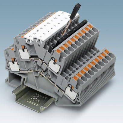 Vícevrstvá šedá řadová svorkovnice s odnímnatelnými bílými svorkovými lištami na kovovém kolejnicovém profilu. Vhodná pro elektrické zapojení.