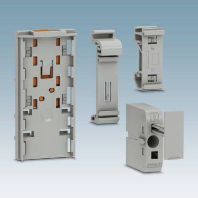 Čtyři šedé plastové elektronické kryty v různých tvarech a velikostech, které stojí vedle sebe na modrém pozadí.