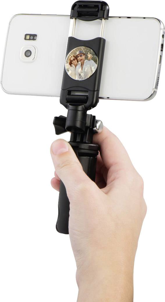 Jedna ruka drží selfie tyč se smartphonem, který zobrazuje fotografii dvou osob.