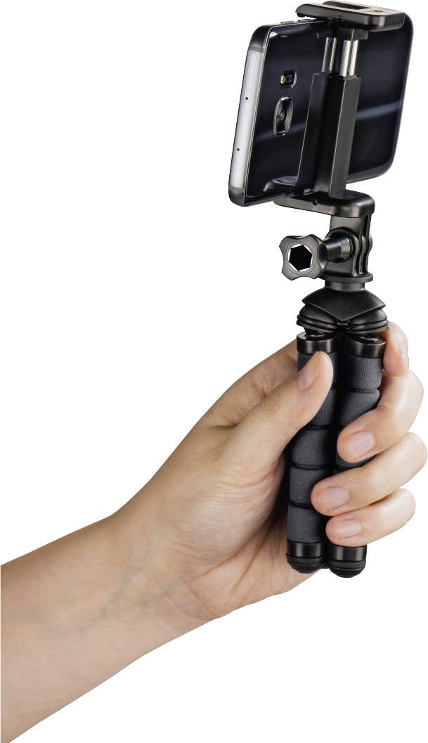 Jedna ruka drží malý stativ, do kterého je upevněn smartphone. Stativ má ohebné nohy pro flexibilní nastavení polohy.
