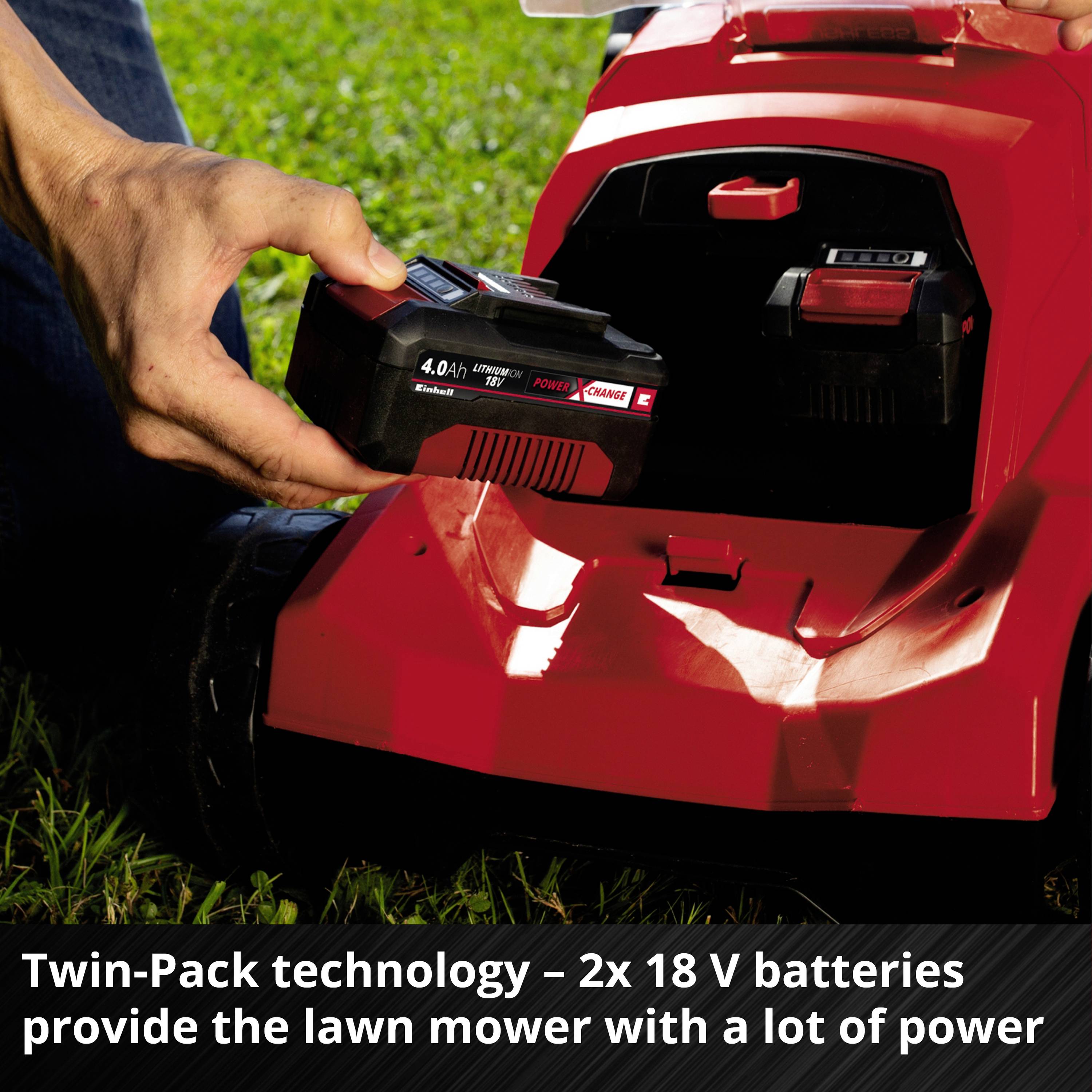 Osoba vkládá akumulátor do červené sekačky. Text na obrázku: 'Technologie Twin-Pack – 2 x 18 V akumulátory zásobují sekačku velkým výkonem'.