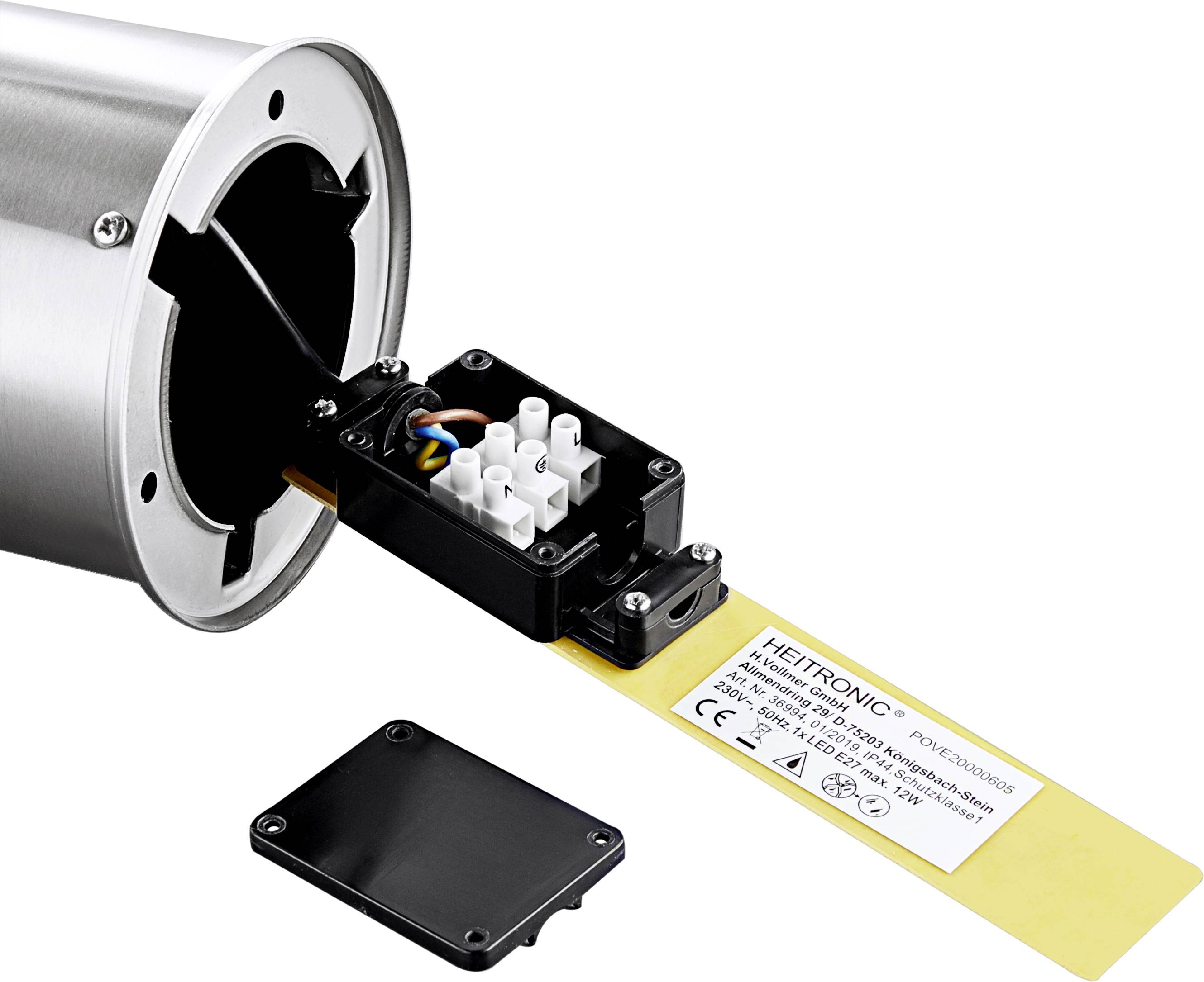 Elektrický rozvodný blok s kabely pro válcové kovové zařízení. Vedle leží kryt.