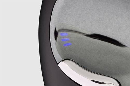 Stříbrný, hladký objekt se třemi modrými svítícími značkami, pravděpodobně indikátor technického stavu zařízení.