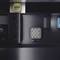 Obdélníkový kovový tácek s malým LED displejem zobrazujícím vlajku EU, umístěný v tmavém prostředí.