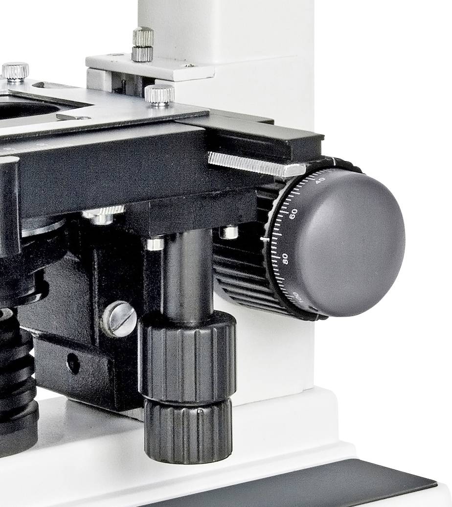 Detailní záběr mechanismu mikroskopického stolku s nastavovacím kolečkem. Viditelné konstrukční detaily slouží k přesnému zaostřování vzorků.