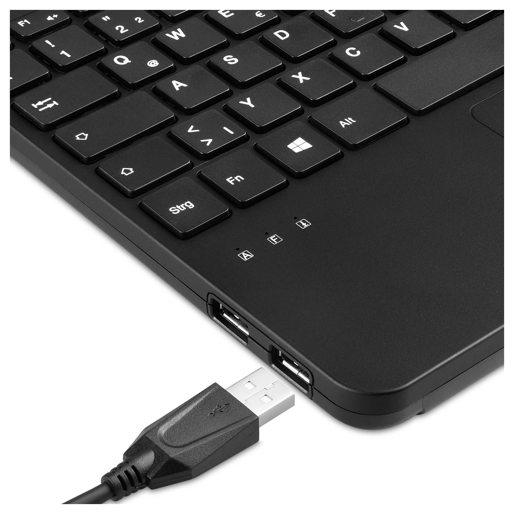 Černá počítačová klávesnice s německým rozložením. Vedle ní leží USB kabel připravený k zapojení do jednoho z USB portů.