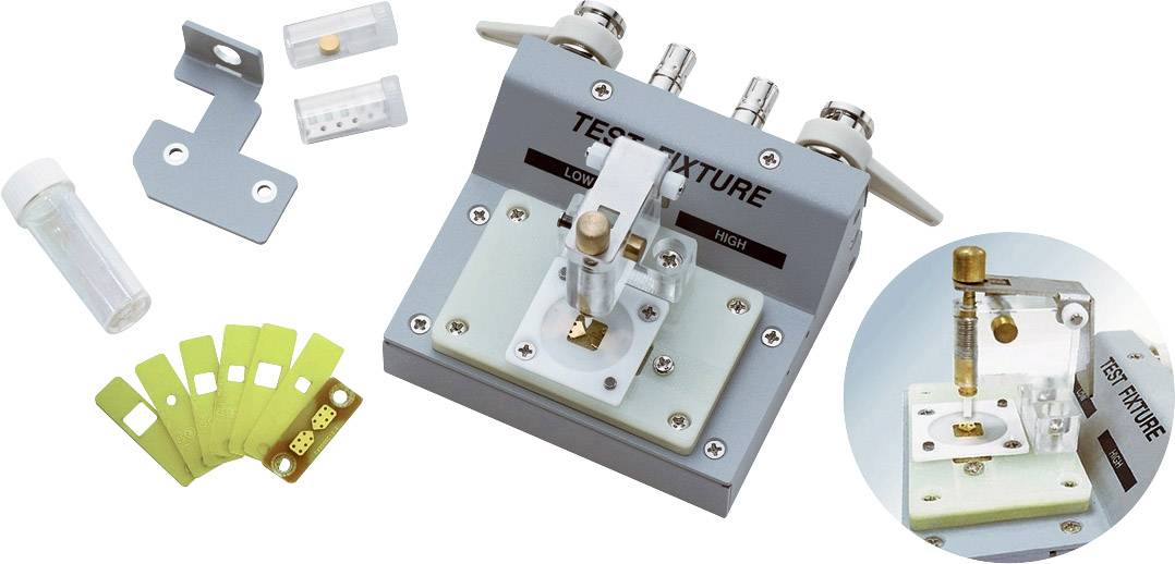 Testovací zařízení s příslušenstvím pro zkoušení elektronických součástek. Obsahuje držák vzorků, testovací proužky a připojovací mechanismy.