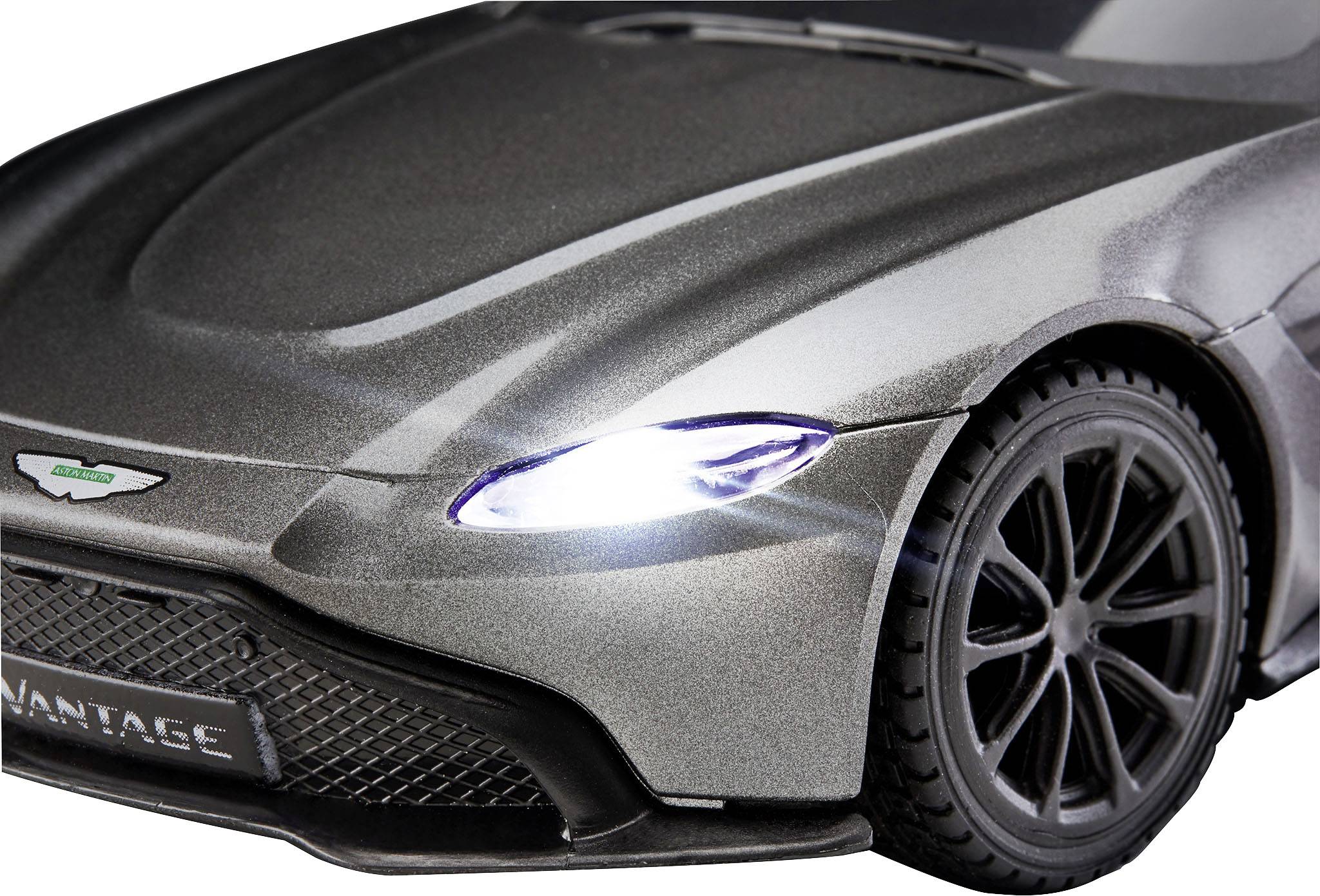 Stříbrný modelový vůz pohledem zepředu ukazuje výrazný přední design s osvětlenými světlomety a značkovým emblémem na chladiči.